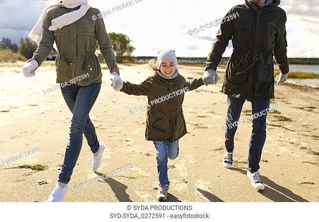 happy family running along autumn beach