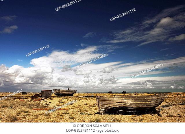 England, Kent, Dungeness. Abandoned wooden fishing boats beached on the shingle beach at Dungeness