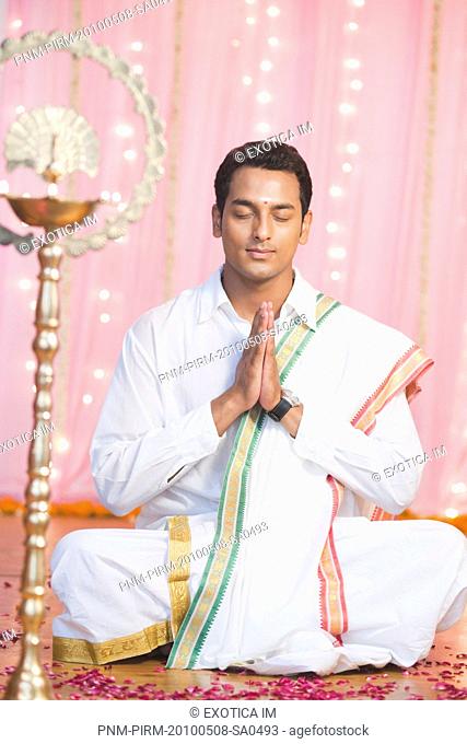 Man praying in traditional South Indian dress