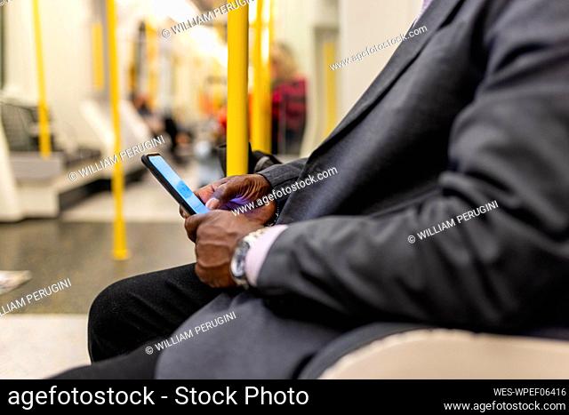 Senior commuter using mobile phone in subway train
