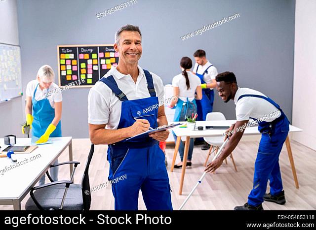 Janitor With His Team Cleaning Modern Office