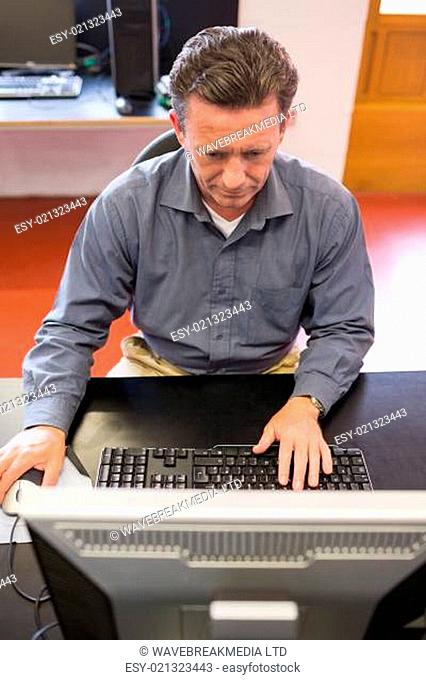 Concentrating man working at the computer in class
