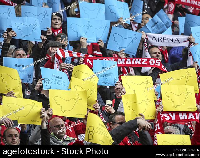 Mainz fans, soccer fans hold yellow and blue placards with peace doves and demonstrate for peace in Ukraine. Soccer 1st Bundesliga season 2021/2022, 32