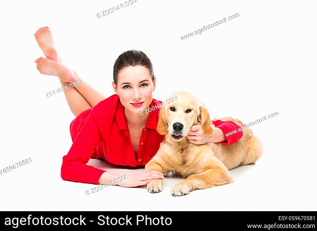 Beautiful young woman with young golden retriever dog lying on floor. Isolated over white background. Copy space