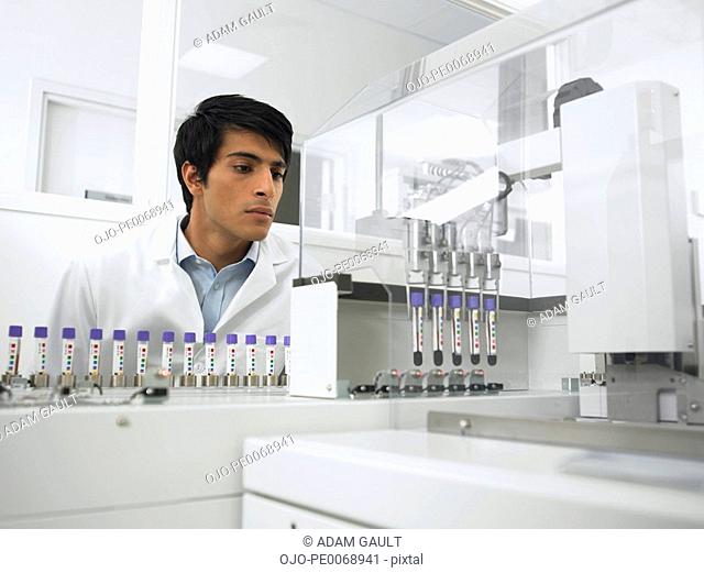 Scientist watching test tubes in machine