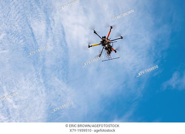 A drone with a camera hovers overhead in the sky