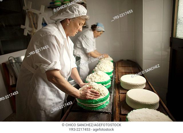 Women work making Pecorino cheese in Quesos Oliva artisanal cheese making workshop in Villaluenga del Rosario, Sierra de Grazalema Natural Park, Cadiz province