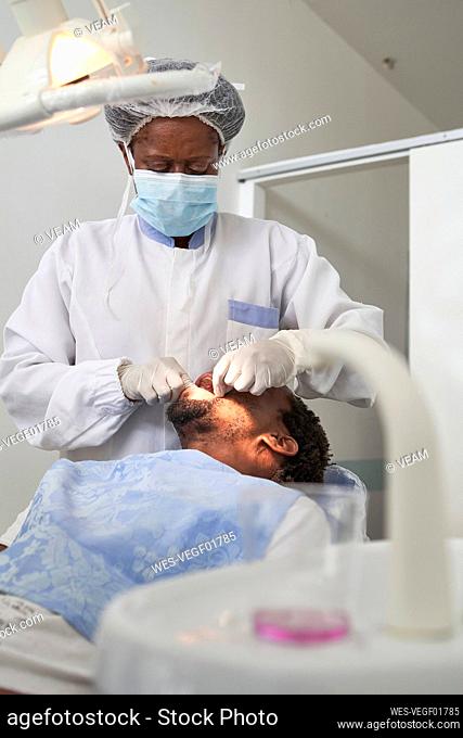 Female dentist examining teeth of a man