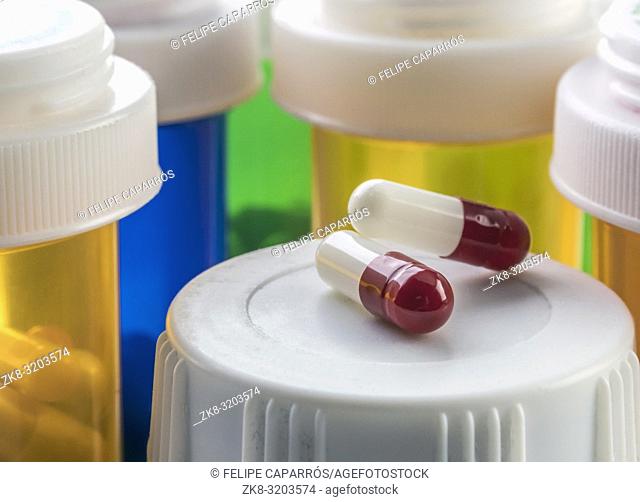 Two capsules red and white on a bottle of medicine, conceptual image