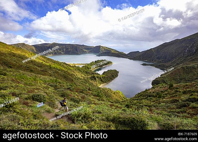 Hiker at the crater rim with view to the crater lake Lagoa do Fogo, Sao Miguel Island, Azores, Portugal, Europe