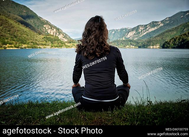 Mature woman sitting in front of lake