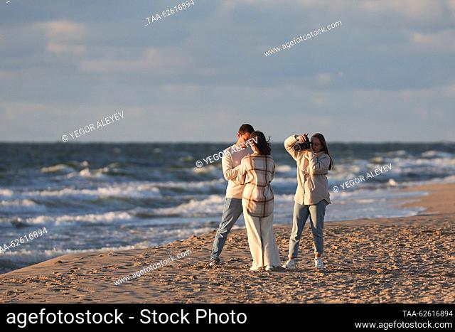 RUSSIA, KALININGRAD REGION - SEPTEMBER 24, 2023: A woman takes a picture of a couple by the Baltic Sea in the village of Yantarny. Yegor Aleyev/TASS