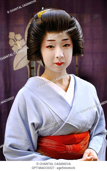 PORTRAIT OF A GEIKO GEISHA IN A KIMONO OBEDE WEARING A WIG KATSURA WITH A HIGH CHIGNON ADORNED WITH A DECORATED HAIRPIN KANZASHI AND MADE UP WITH THE...