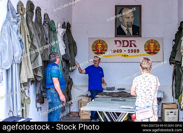 24 July 2020, Saxony-Anhalt, Beuster: Hubert Pinick from the Fire Brigade Museum Schwerin explains to visitors in an exhibition room during the Blue Light Days...