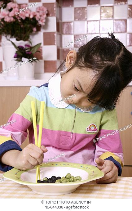 Korean Girl Learning to Use Chopsticks