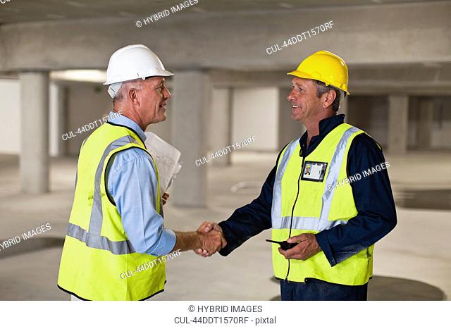 Workers shaking hands on site