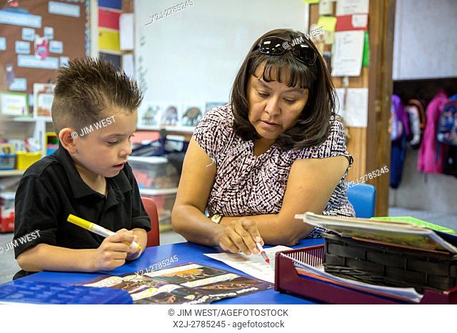 Thoreau, New Mexico - Classroom assistant Jennifer Vandever works with a student in a kindergarten classroom at St. Bonaventure Indian School