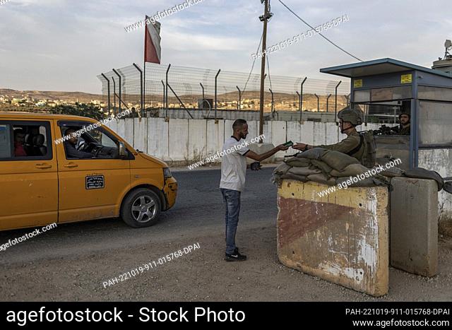 19 October 2022, Palestinian Territories, Bet Fajr: Israeli soldiers check the ID of Palestinians at a military checkpoint amid tight military closures in the...