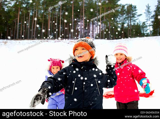 happy little kids playing snowball fight in winter