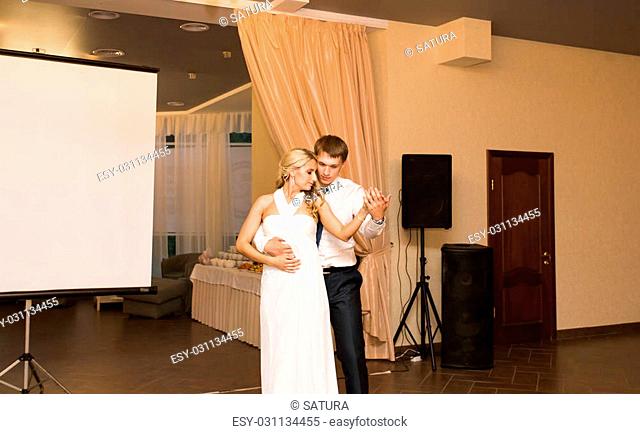 beautiful caucasian couple just married and dancing their first dance