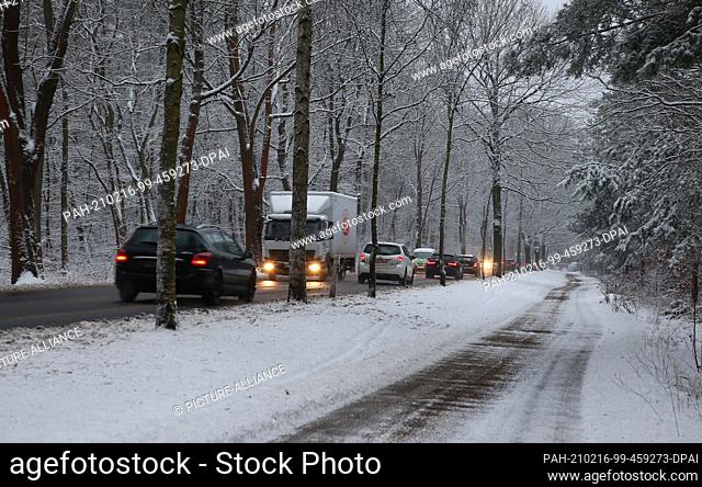 16 February 2021, Berlin: Cars are jammed on a road. Fresh snow from last night and glassy roads are causing obstructions in the morning rush hour traffic at...