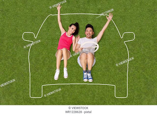 Young people lying on grass in an artificial car