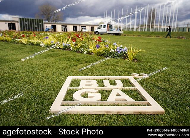 30 March 2023, Baden-Württemberg, Mannheim: A wooden frame with the inscription ""BUGA 23"" lies in front of a flower bed on the grounds of the Federal...