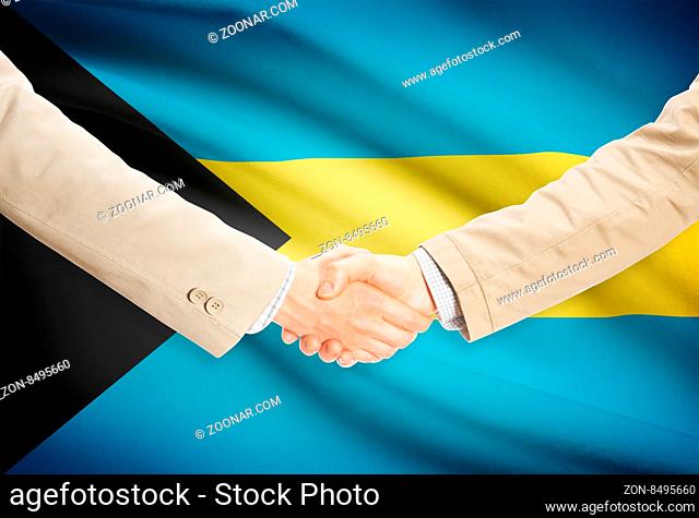 Businessmen shaking hands with flag on background - Bahamas