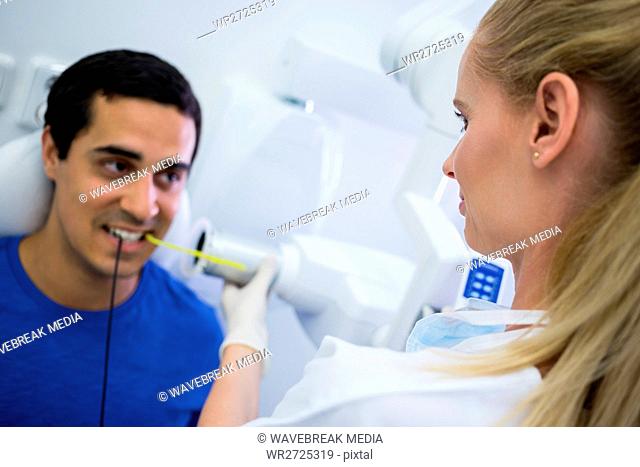 Female dentist taking x-ray of patients teeth