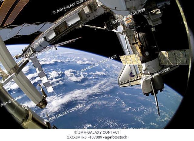 Backdropped by the blackness of space and Earth's horizon, the docked Space Shuttle Atlantis (STS-115) and a Soyuz spacecraft are featured in this image...