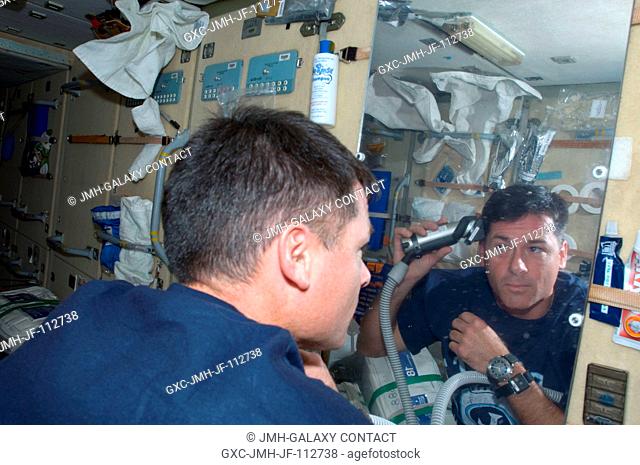 Astronaut Shane Kimbrough, STS-126 mission specialist, gives himself a hair trim on the aft side of the Zarya functional cargo block aboard the International...