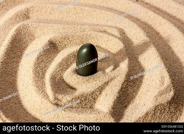 .Black stone sticking out of the sand can be used as background