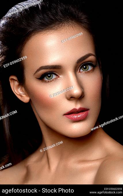 Beautiful young woman with cat eye liner make up. Beauty shot on black background. Copy space