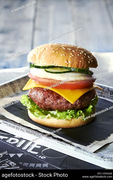 Burger with lettuce, cheese, tomato, onion, and pickles