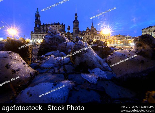 25 January 2021, Saxony, Dresden: Remnants of snow lie in the morning on the Theaterplatz in front of the Hofkirche (l-r), the equestrian statue of King Johann