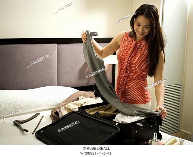 Close-up of a young woman packing her suitcase