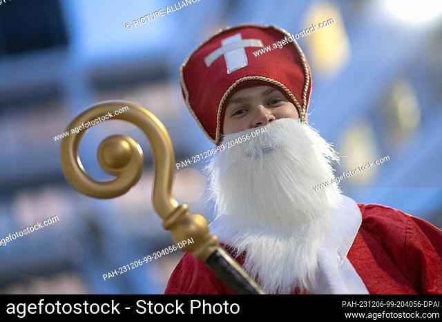 06 December 2023, Lower Saxony, Göttingen: A costumed Santa Claus stands in front of the south facade of Göttingen Children's Hospital