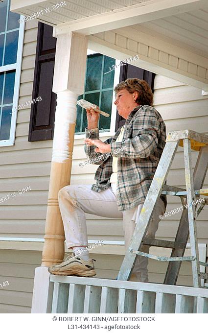 Woman painting new house porch