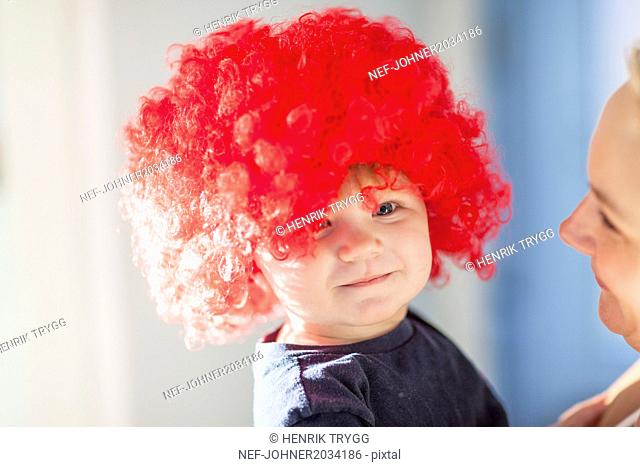 Baby boy wearing red wig
