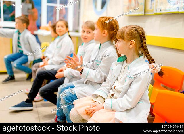 Children in uniform learning doctor profession in classroom, playroom. Kids plays medicine worker in imaginary hospital, childish dream