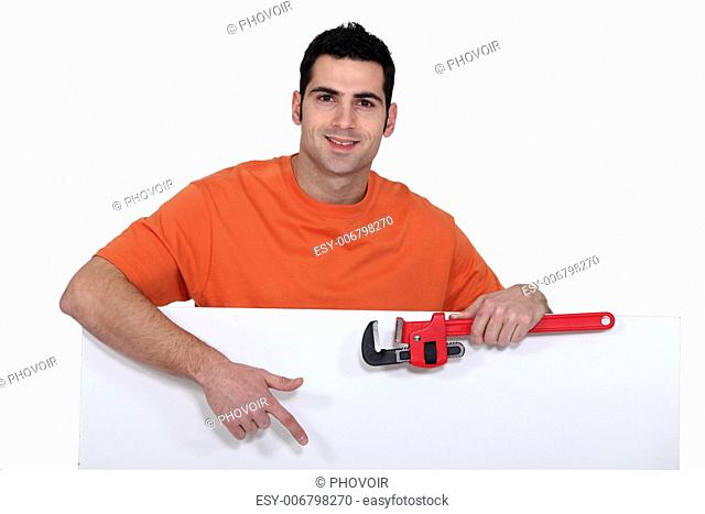 Man stood with wrench and poster