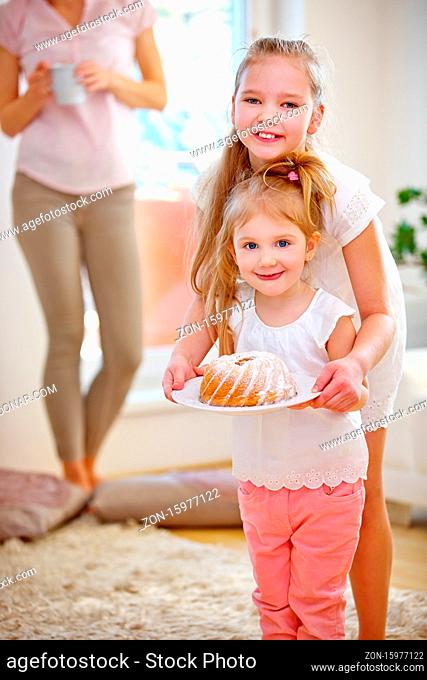 Zwei Kinder mit einem Kuchen zum Geburtstag zu Hause