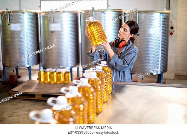 Female worker checking oil bottles