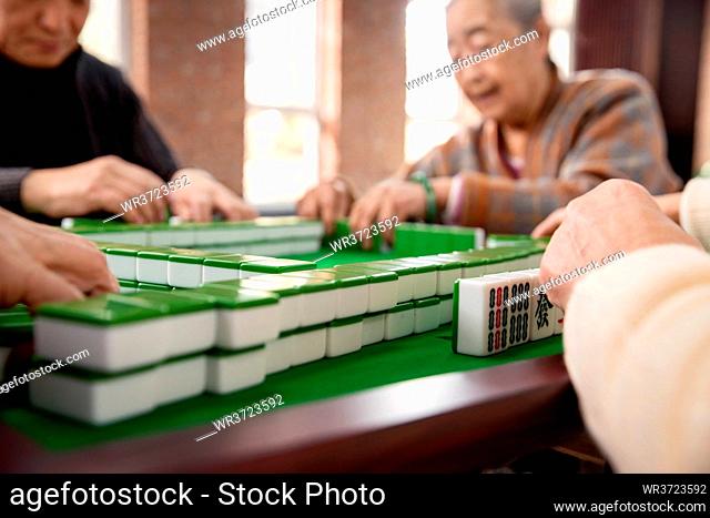 Happy old people playing mahjong