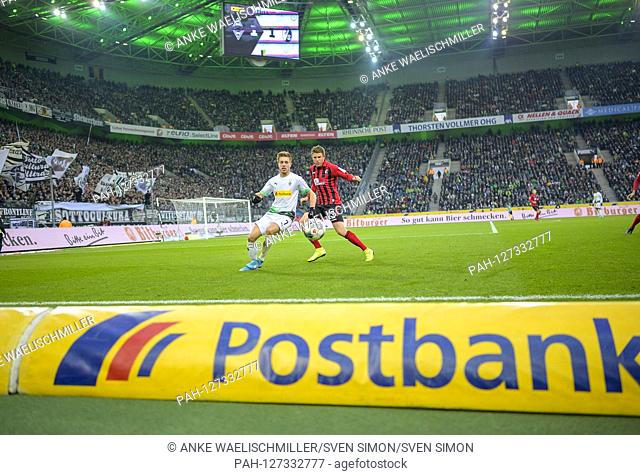 Feature, advertising band of ""Postbank"" on the sidelines, behind a game scene with Patrick HERRMANN l. (MG) versus Dominique HEINTZ (FR), Action, Football 1