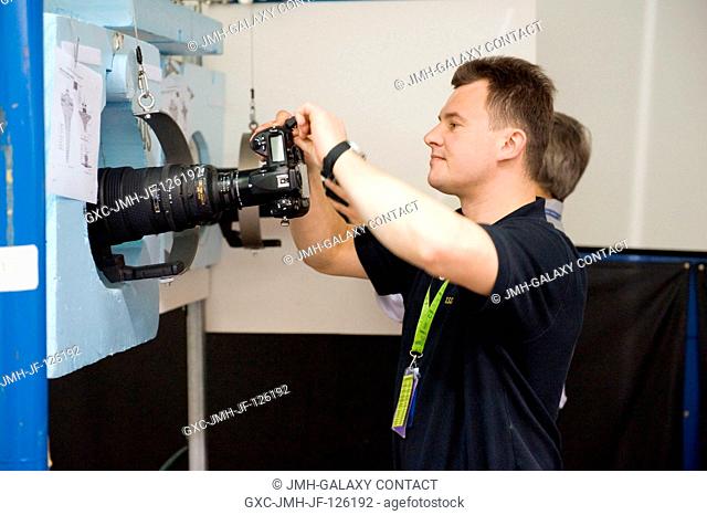 Cosmonaut Roman Romanenko, Expedition 2021 flight engineer, prepares to use a still camera during a training session in the Space Vehicle Mock-up Facility at...