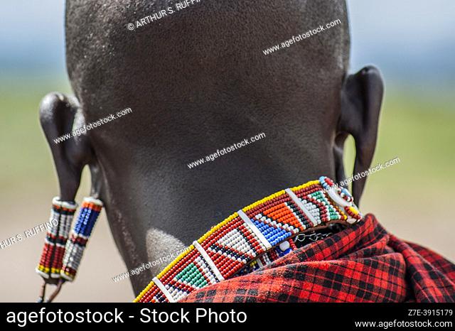 Portrait detail of a Masai man with stretched earlobes wearing beaded earrings. Masai Village, Amboseli National Park, Kenya, Africa