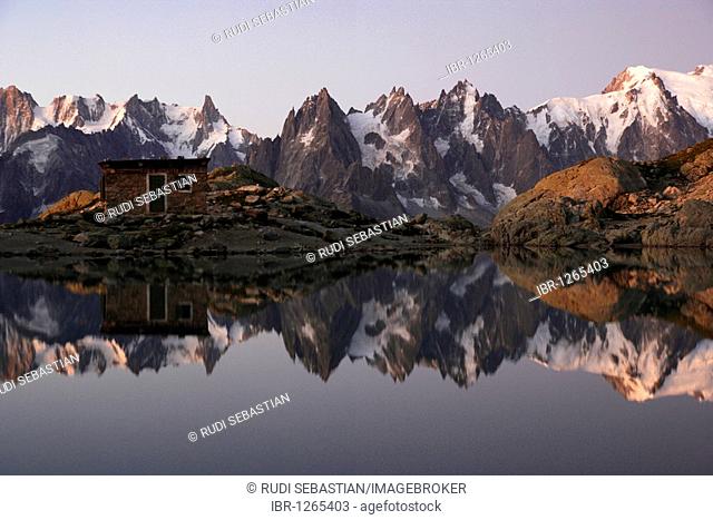 The Aiguilles de Chamonix mountains reflected in Lac Blanc lake, far right Mont Blanc before sunrise, Haute-Savoie, France, Europe