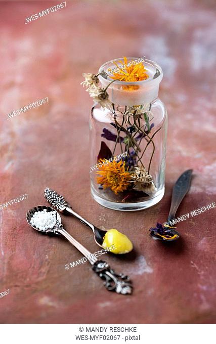Blossoms of medical plants, medicine flask, marigold salve and globules
