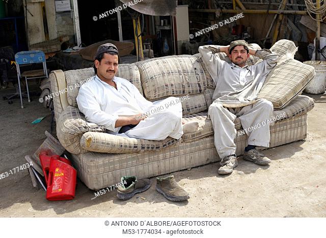 two pakistani man waiting for customer in a mechanical repairs workshop  old ras al-khaimah  ras al-khaimah  united arab emirates  middle east